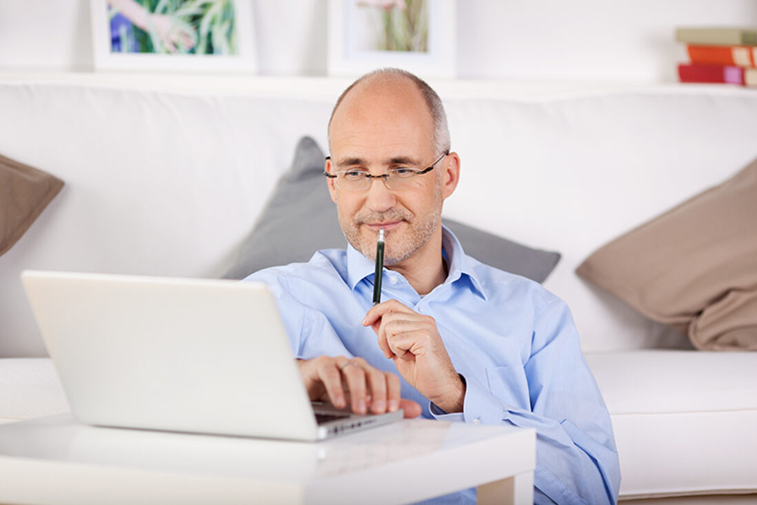 21145745 – businessman working through his laptop while leaning on the couch